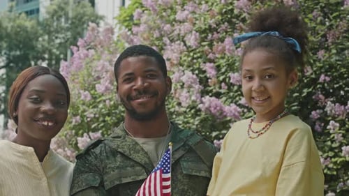 Family Poses Outdoors Holding American Flag