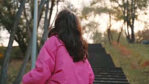 Cute Young Woman Walking in the Park in Golden Autumn Against Wooden Staircase Autumn Urban Street