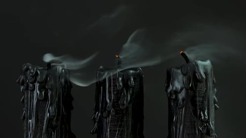 Black Candles Burning and Smoking Against Dark Background