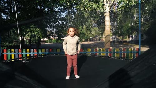Girl Jumping on Trampoline in an Urban Park