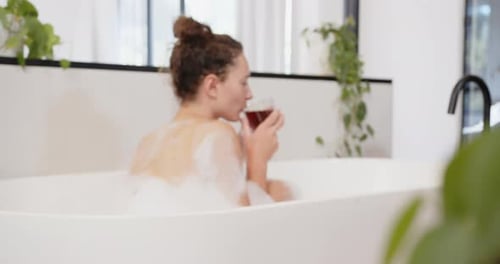 Woman Enjoys Relaxing Bath with Drink Indoors