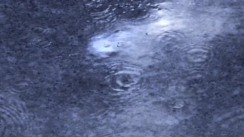 Rain splashes hit the asphalt, heavy rain, close-up