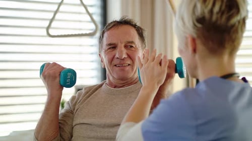 Healthcare professional assists senior patient in wheelchair during hospital physiotherapy