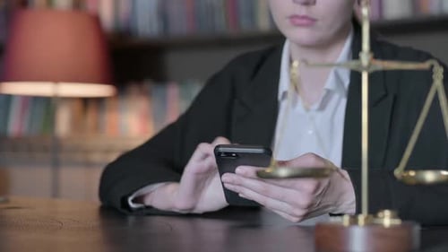 Close up of Female Lawyer using Smartphone, Scale of Justice