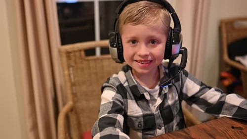 Smiling Child Wearing Headphones at a Desk