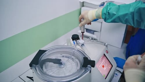 Medical Professional Using Syringe on Medical Device