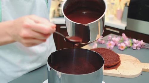 Woman Icing Chocolate Cake With Melted Chocolate
