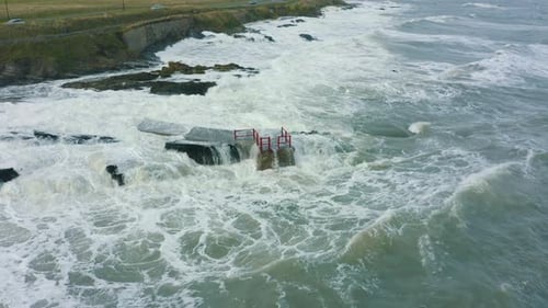 Aerial view of waves crashing against rocks along the coastline during a storm.
Drone Footage.