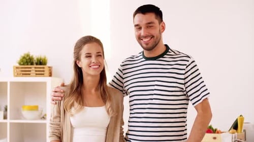 Smiling Young Couple Embracing in a Bright Kitchen