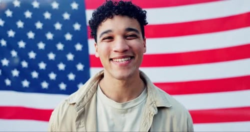 Smiling Young Man Poses Before American Flag