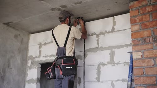 Electrician Installs Wiring in an Unfinished Room
