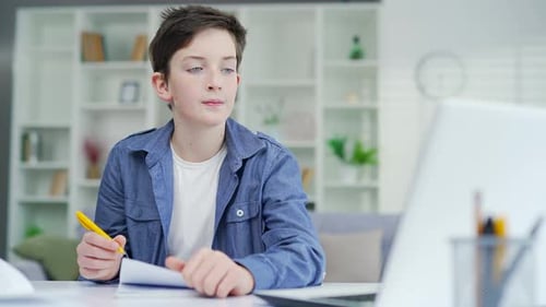 Teen Boy Studying and Writing at Home