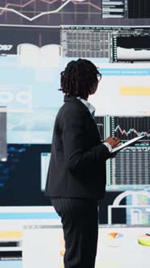 Vertical Video Business Specialist Using Tablet to Review Performance Dashboards Metrics