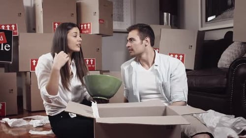 Couple unpacking moving boxes together in new home