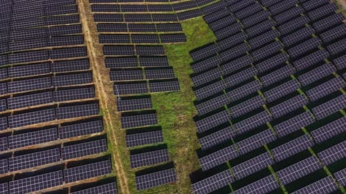 Solar energy panel field with rows of solar panels on farmland