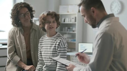 Woman and Her Little Son Consulting with Pediatrician in Medical Office