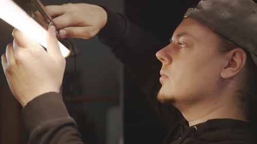 Young Caucasian Lighting Technician Installing Lamp in Studio