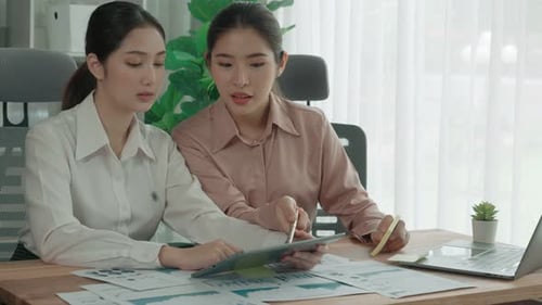 Two Young Enthusiastic Businesswoman Working Together in the Office Workspace