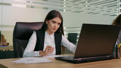 Concentrated business woman working online on computer at office.