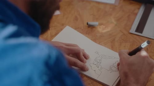 Artist Sketching Fantasy Drawing at Wooden Table