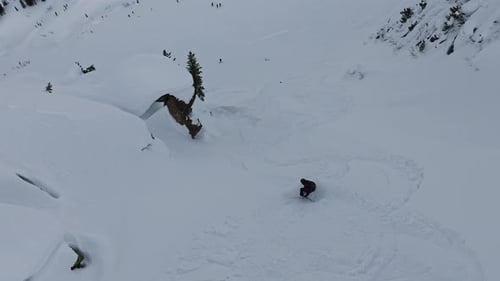 Skier Performing Tricks in Fresh Powder Snow Near Cliff