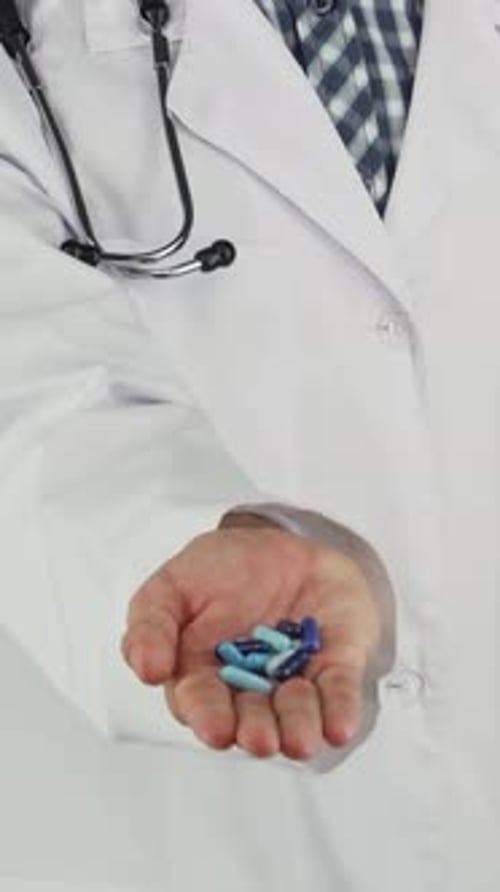 Medical Professional Holding Blue Pills in Hand