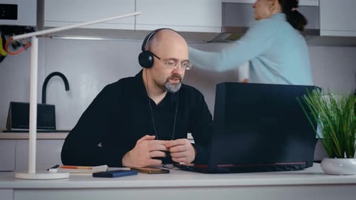 Un homme jure et crie après une femme parce qu'elle interfère avec la tenue d'une vidéoconférence professionnelle