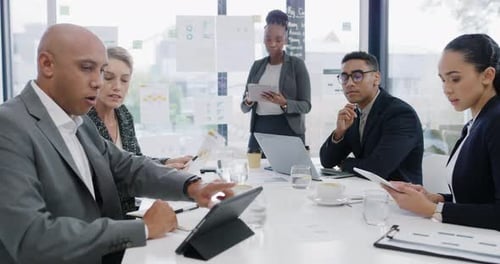 4k video footage of a group of businesspeople using a digital tablet during a meeting in an office