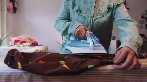 Woman Ironing Dress on Ironing Board