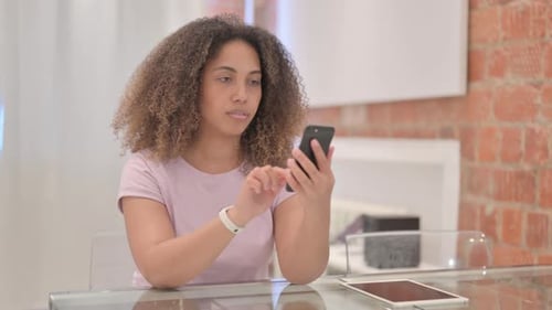 Woman Using Smartphone at Glass Table