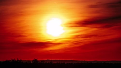 Timelapse of Dramatic Sunset in the Orange Sky Through Clouds