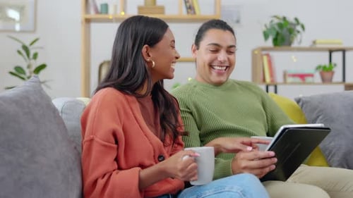 Happy Young Couple Using Tablet on Couch