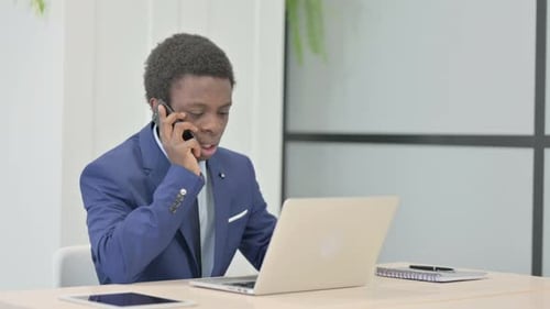 Young Adult talking on phone in office