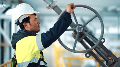 Asian Male Metalworker in Helmet Rotation Wheel Rig Mechanic Gear Detail at Industrial Production