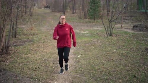 Young Woman Jogging on Path in Park