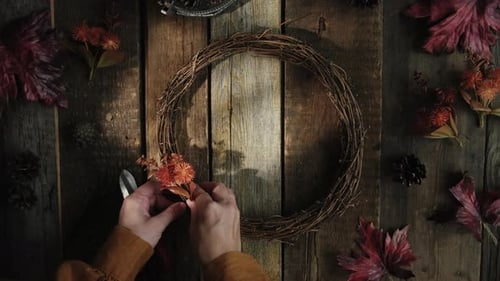 Woman Creating Autumn Wreath with Leaves and Flowers