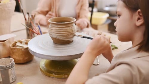 Girl Adding Clay to Pottery in Art Studio