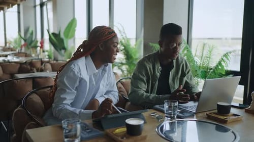 Successful Black Professionals Planning Business Strategy Over Coffee in the Cafe