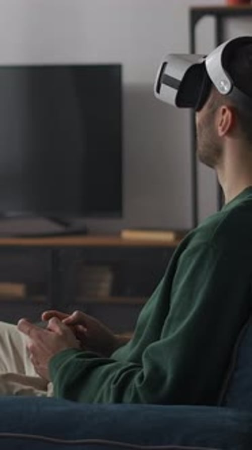 Man Using VR Headset on Sofa in Living Room
