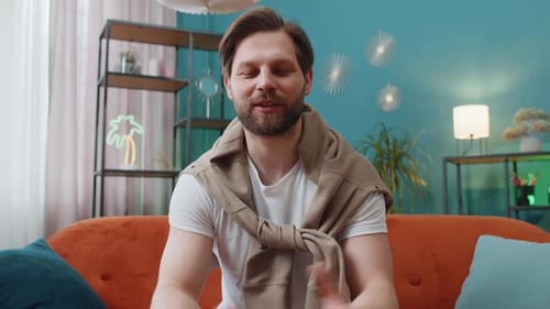 Man Talking and Waving on Living Room Couch