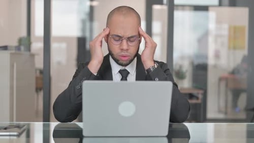 Stressed Businessman Working on Laptop in Office