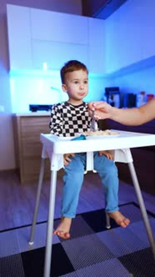 Cute Child Eating a Meal in Kitchen
