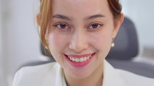 A professional woman smiles confidently during a business meeting in a modern office.