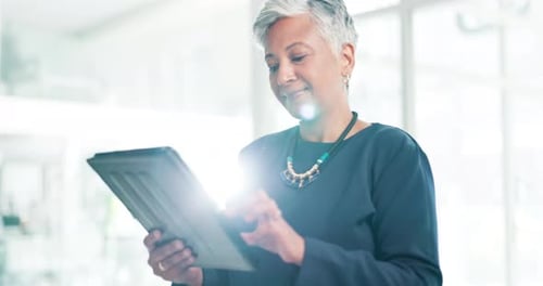 Business, senior and happy woman on tablet for research, social media or communication at office