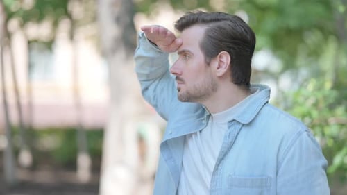 Man Looking into Distance in Park