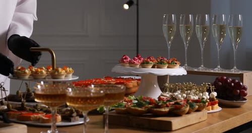 Chef arranging appetizers for buffet at table, closeup. Camera moving left