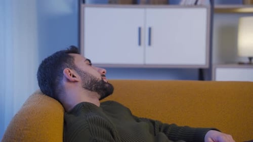 Man Lying on Couch Resting Indoors