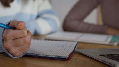 Detail of caucasian mother helping her teenage daughter in doing homework at home. Shot with RED hel