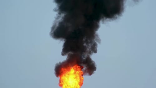 Burning Flame With Billowing Black Smoke Against Sky