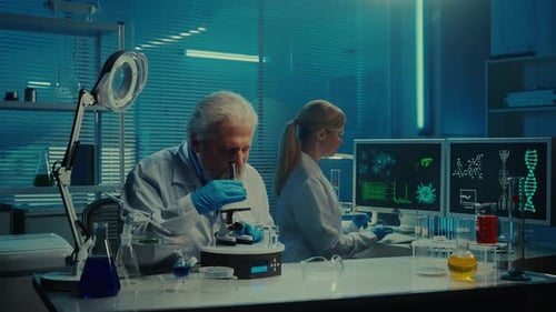 Scientists Working in Modern Lab with Microscope